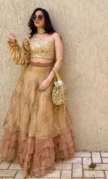 Rose gold ruffled skirt with a one shouldered crop top and a triple layered satin balloon sleeve and matching Potli